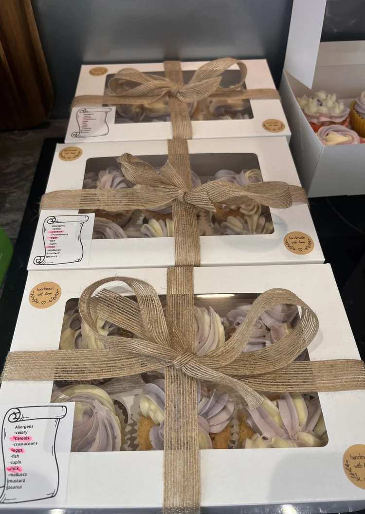 Boxed cupcakes with purple and white frosting