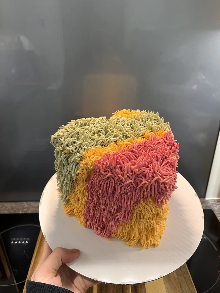 Heart-shaped cake with colorful textured frosting