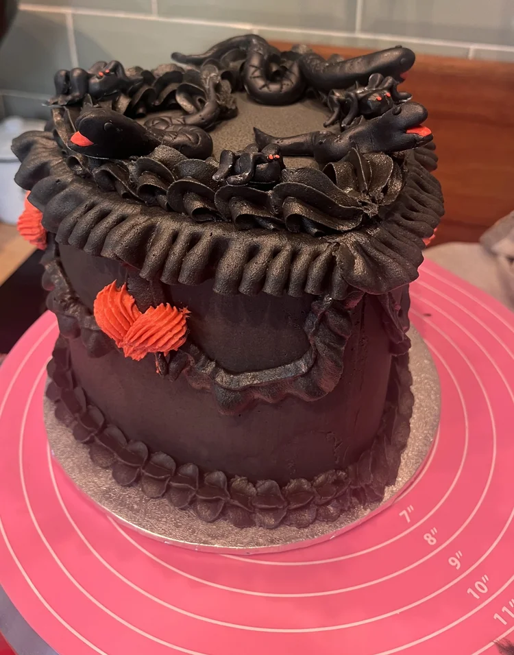 Black cake with red snake decorations